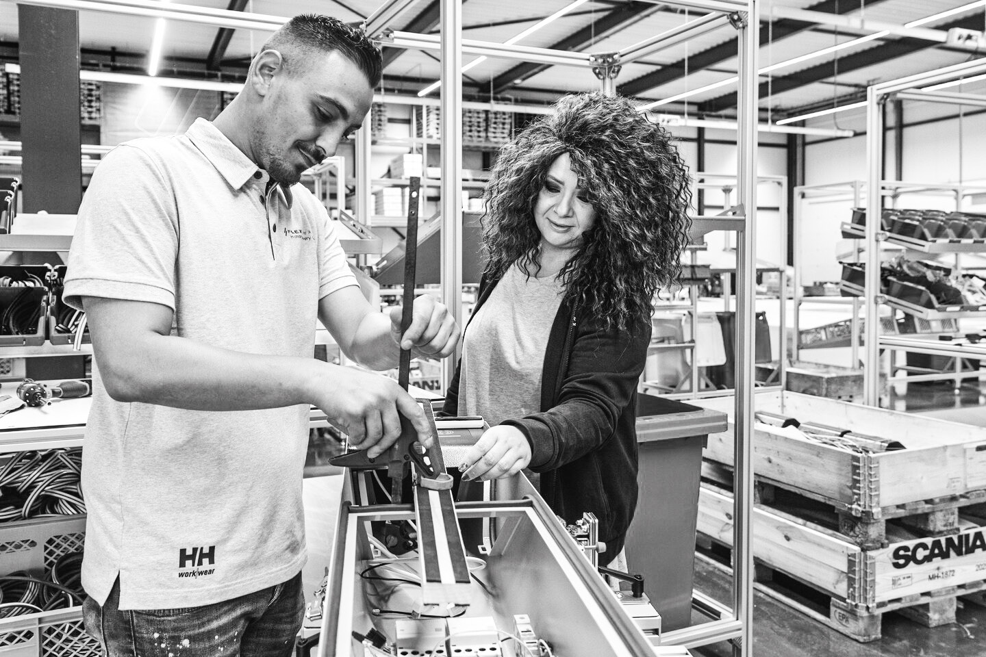 Twee medewerkers van FlexiCharge aan het werk in de werkplaats